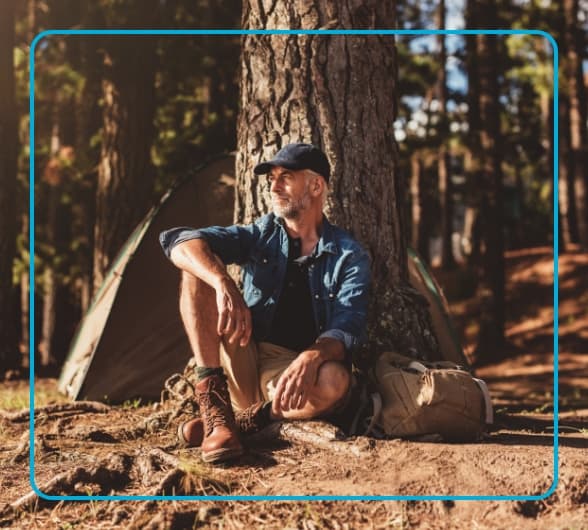 Man sitting against a tree