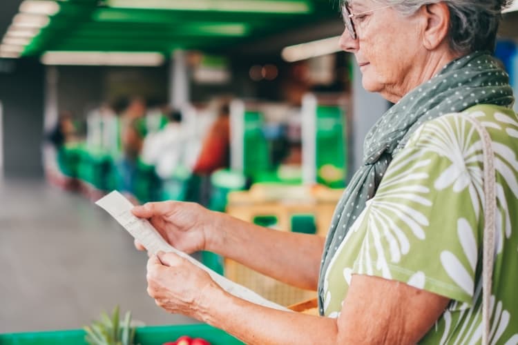 Woman looking at groceries receipt